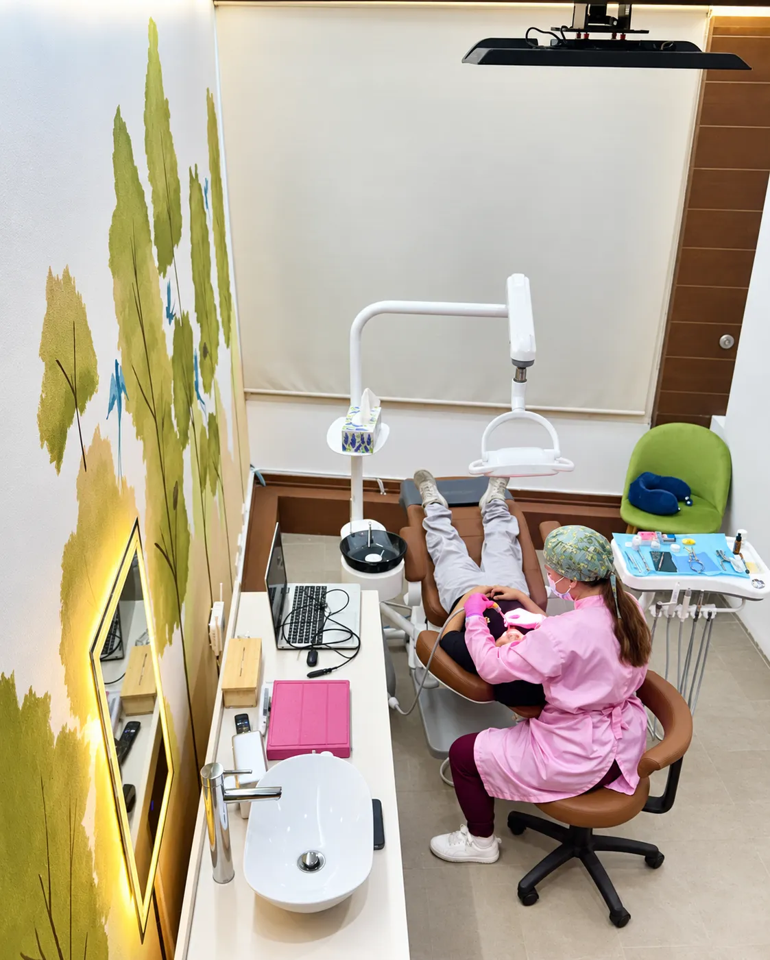 Atención dental en un consultorio de Gratia Odontología con mural de árboles, en San Pedro Garza García